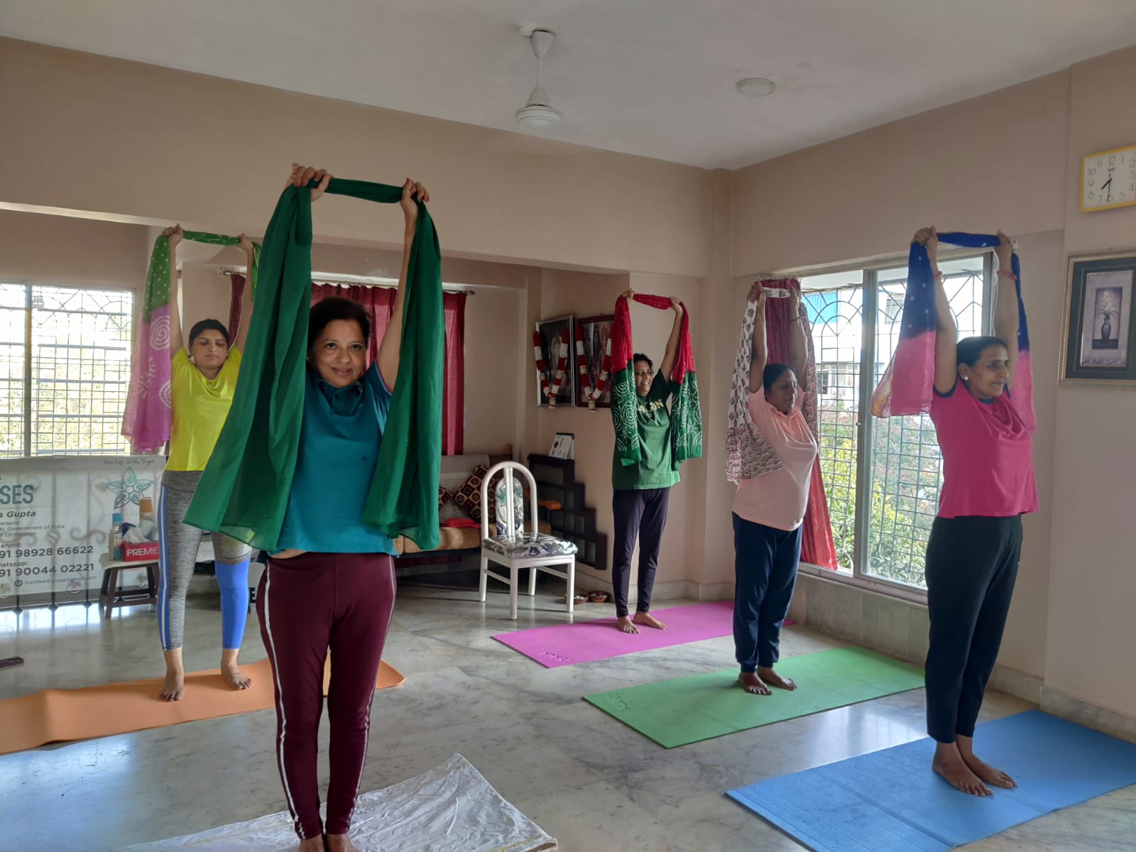 Students practicing standing stretches with scarves