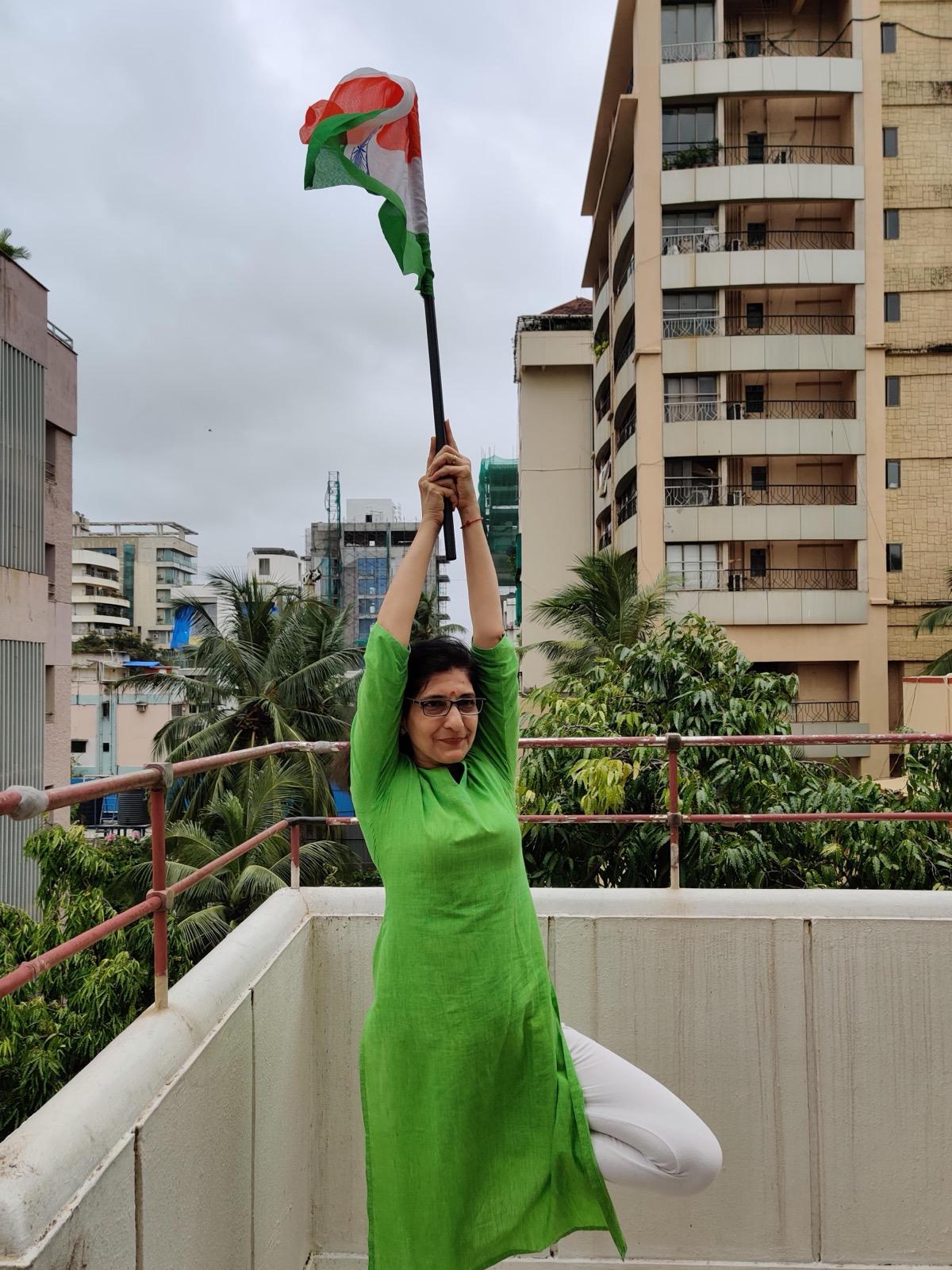 Rachna in vrksasana holding the Indian flag